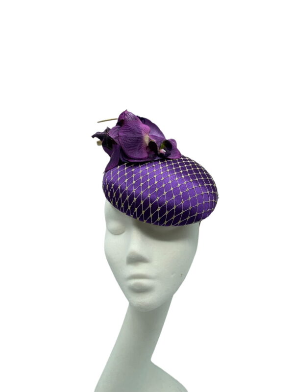 Stunning purple headpiece with matching orchid flower detail and finished with a gold veiling overlay on the base.
